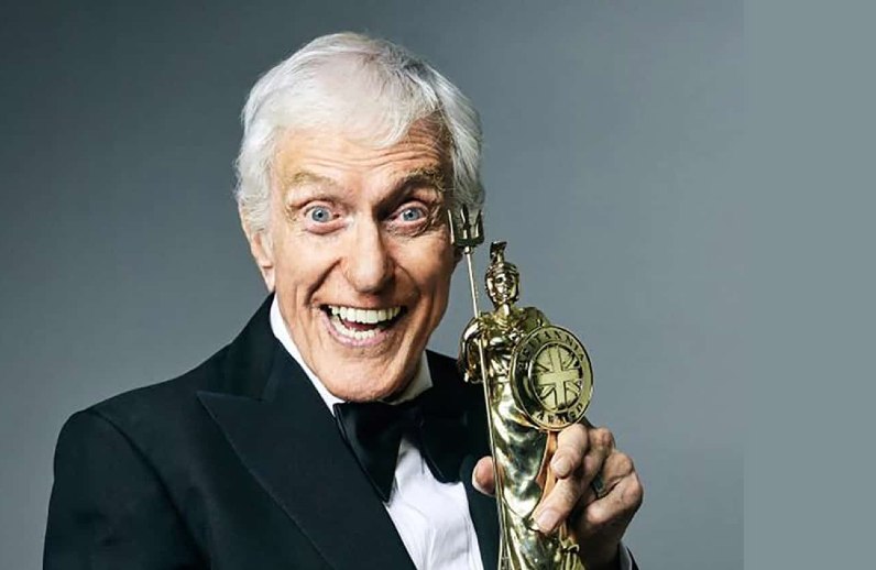 Dick Van Dyke looking excited holding a statue