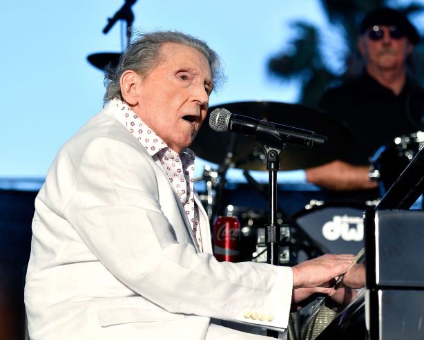 Jerry Lee Lewis in white suit playing piano